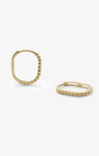 Gold huggie earrings on a white background