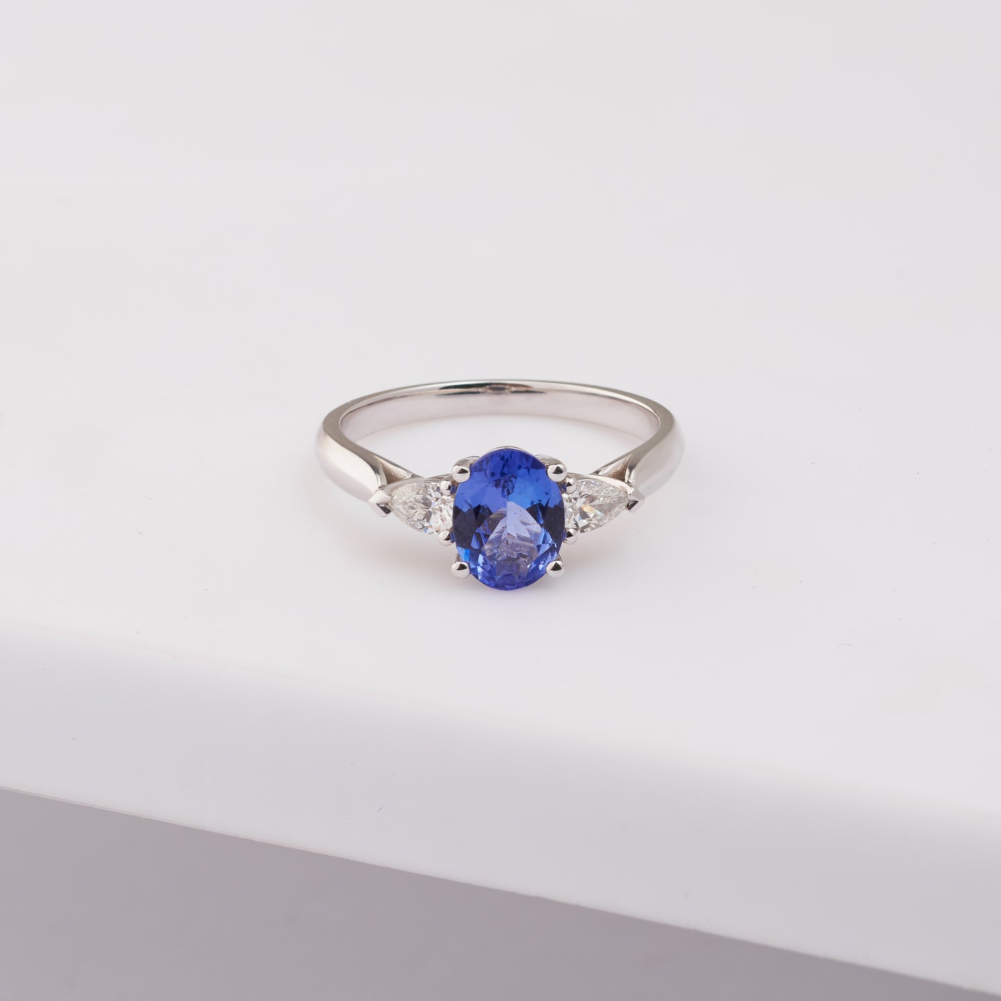 18K White Gold 8mm x 6mm Oval Tanzanite and Pear Diamond Ring.